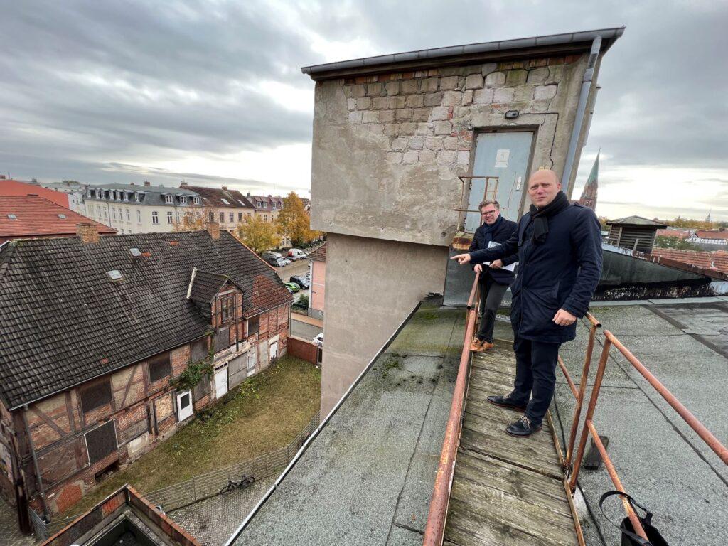 ZGM-Chef Kristian Meier-Hedrich (vorn) auf dem Dach des Speichergebäudes, das zu Zentralarchiv umgebaut werden soll. | Foto: Landeshauptstadt Schwerin / Michaela Christen
